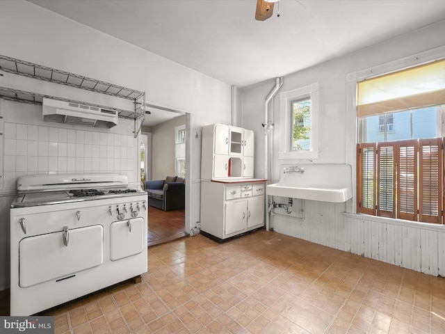 113 Ingleside Ave, Baltimore, MD 21228 - kitchen with gas range gas stove, under cabinet range hood, a sink, decorative backsplash, and ceiling fan