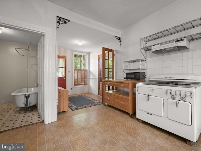 113 Ingleside Ave, Baltimore, MD 21228 - kitchen featuring range with gas stovetop, black microwave, under cabinet range hood, white cabinetry, and backsplash