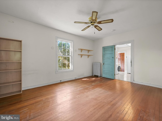 113 Ingleside Ave, Baltimore, MD 21228 - empty room with radiator heating unit, hardwood / wood-style floors, washer / dryer, ceiling fan, and baseboards