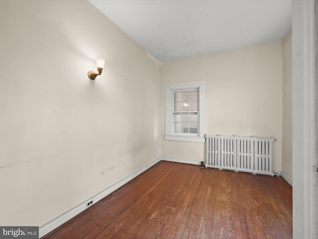 113 Ingleside Ave, Baltimore, MD 21228 - spare room with radiator heating unit, wood-type flooring, and baseboards