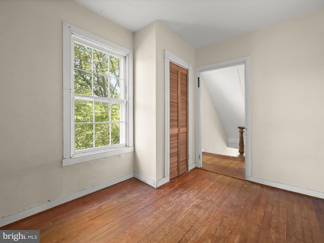 113 Ingleside Ave, Baltimore, MD 21228 - unfurnished bedroom featuring hardwood / wood-style floors, multiple windows, a closet, and baseboards
