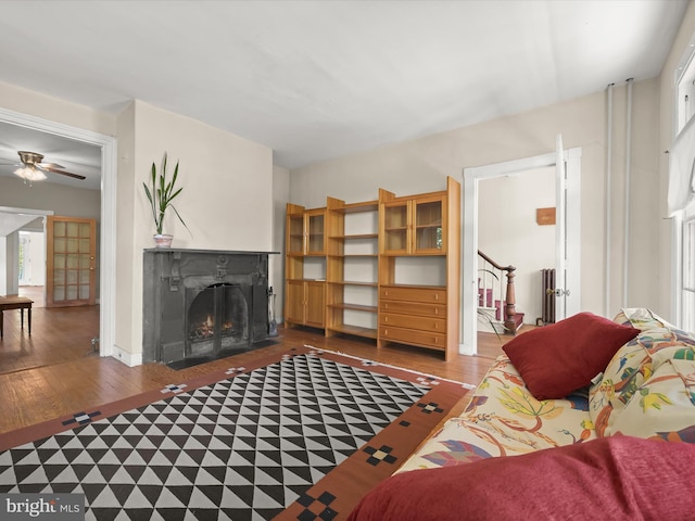113 Ingleside Ave, Baltimore, MD 21228 - living area with a lit fireplace, wood finished floors, stairs, and ceiling fan