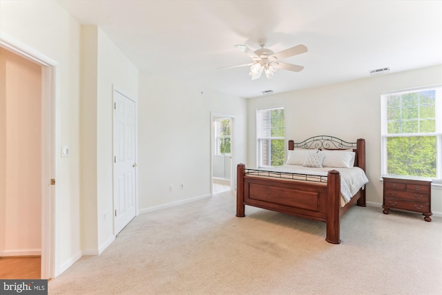 bedroom with light colored carpet, baseboards, visible vents, and ceiling fan