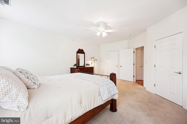 bedroom featuring light colored carpet, ceiling fan, and visible vents