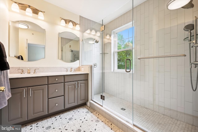 full bath with double vanity, a shower stall, a sink, and tile patterned flooring