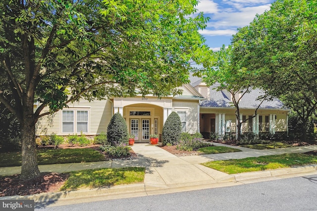 view of property hidden behind natural elements featuring french doors