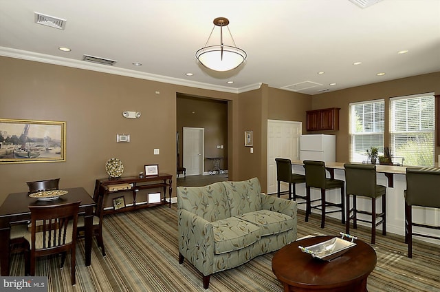 carpeted living area with ornamental molding, recessed lighting, and visible vents