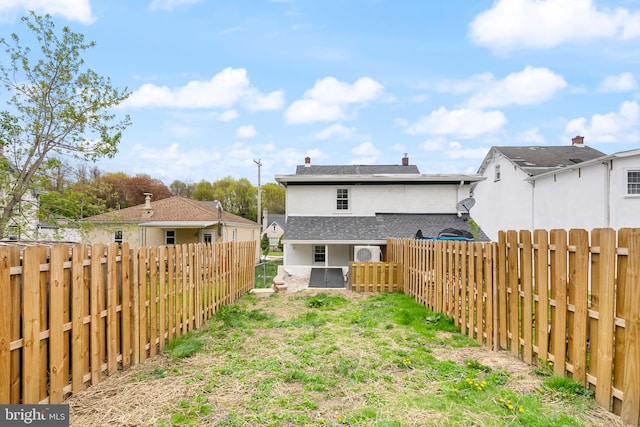 rear view of property with a fenced backyard and stucco siding