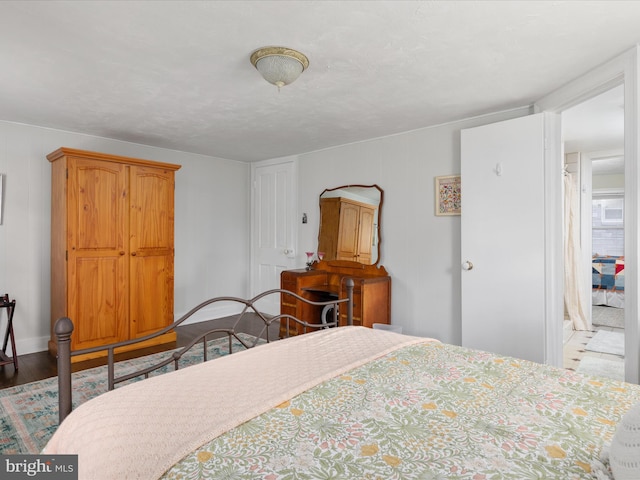 bedroom featuring wood finished floors and baseboards