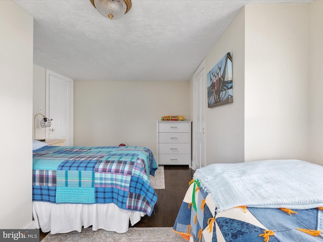 bedroom featuring wood finished floors and a textured ceiling