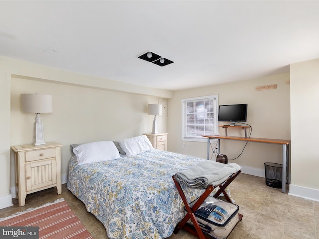 bedroom featuring light tile patterned flooring and baseboards
