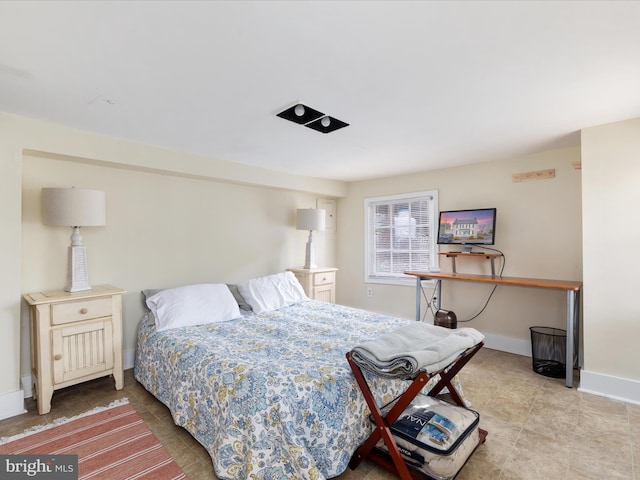 bedroom featuring baseboards and light tile patterned floors