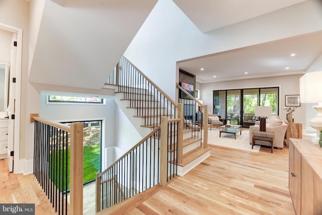 stairs featuring wood finished floors and recessed lighting