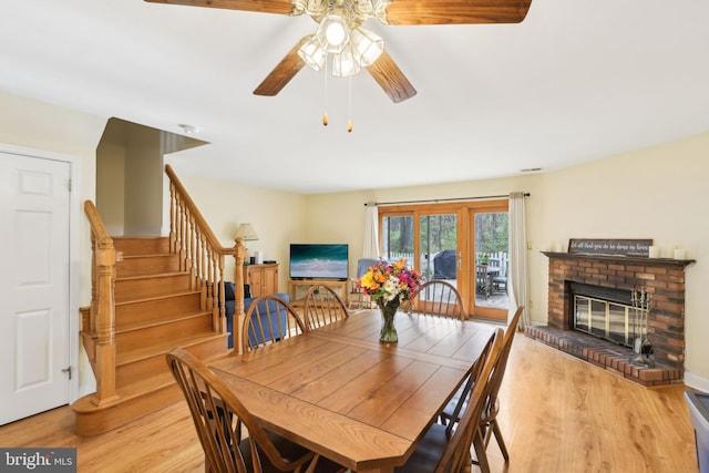 9 Stratton Ct, Robbinsville, NJ 08691 - dining room with stairs, a ceiling fan, a fireplace, and light wood-style floors
