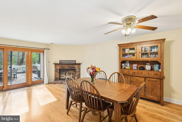 9 Stratton Ct, Robbinsville, NJ 08691 - dining area featuring a brick fireplace, light wood finished floors, baseboards, and a ceiling fan