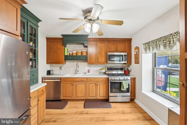 9 Stratton Ct, Robbinsville, NJ 08691 - kitchen with stainless steel appliances, light countertops, a sink, light wood-style flooring, and tasteful backsplash