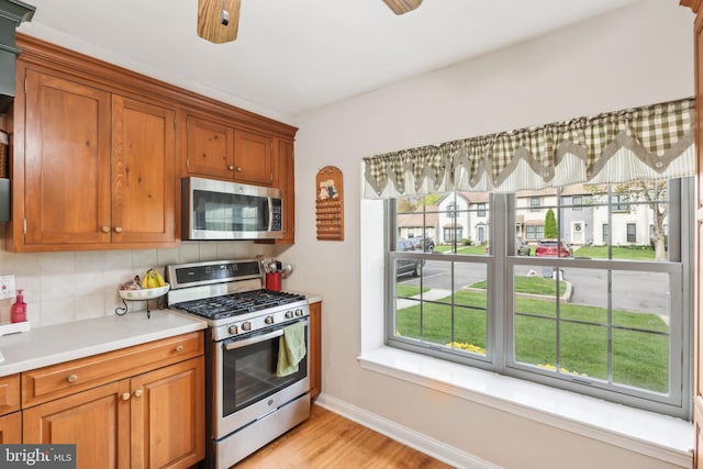 9 Stratton Ct, Robbinsville, NJ 08691 - kitchen with brown cabinetry, decorative backsplash, stainless steel appliances, and light countertops