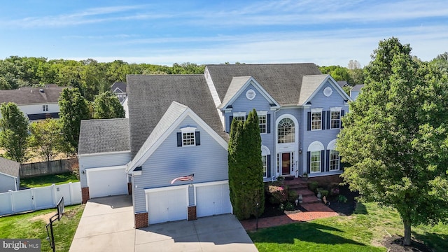 1005 Chaff Way, La Plata, MD 20646 - traditional-style house with a front lawn, brick siding, roof with shingles, concrete driveway, and fence