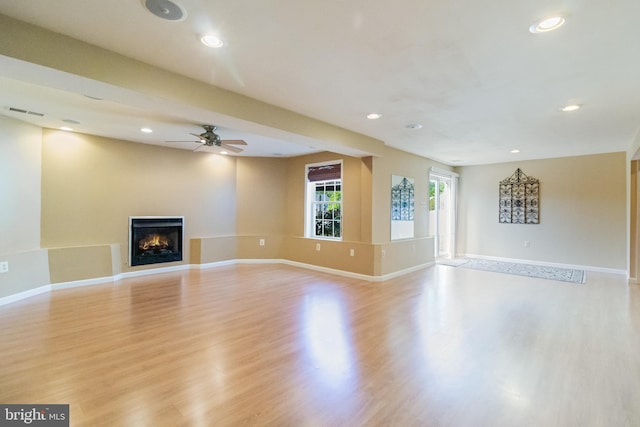 1005 Chaff Way, La Plata, MD 20646 - unfurnished living room featuring visible vents, light wood-type flooring, ceiling fan, and a warm lit fireplace