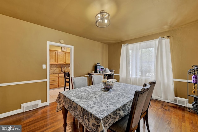 1386 Pentwood Rd, Baltimore, MD 21239 - dining area with baseboards, wood finished floors, and visible vents