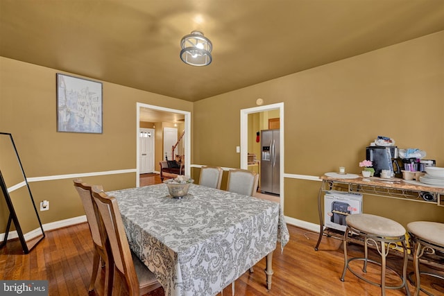 1386 Pentwood Rd, Baltimore, MD 21239 - dining room featuring stairway, baseboards, and wood finished floors