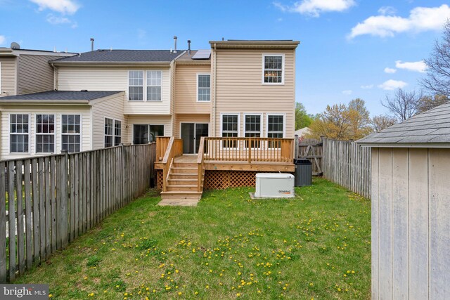 rear view of property with roof mounted solar panels, a fenced backyard, a yard, and central air condition unit