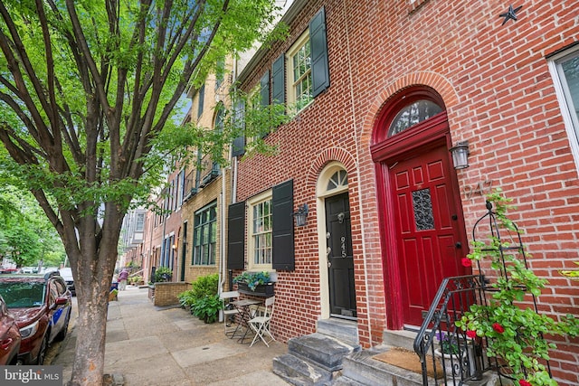 view of exterior entry featuring brick siding