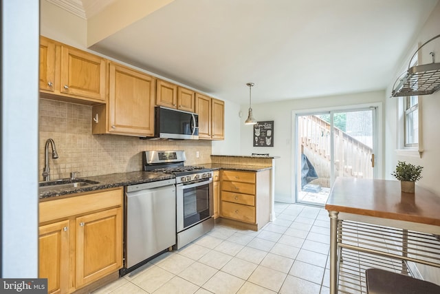 kitchen featuring appliances with stainless steel finishes, tasteful backsplash, a sink, and light tile patterned floors