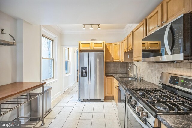 kitchen featuring stainless steel appliances, a sink, ornamental molding, light tile patterned floors, and backsplash