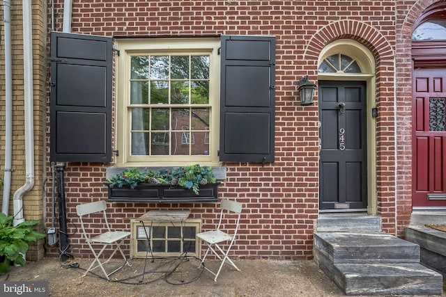entrance to property featuring brick siding