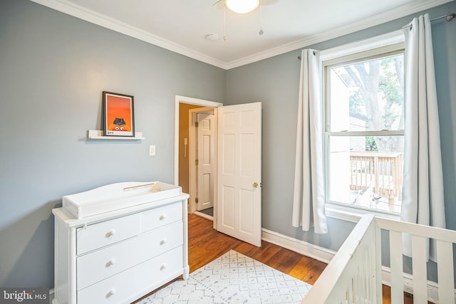 bedroom with ornamental molding, wood finished floors, and baseboards