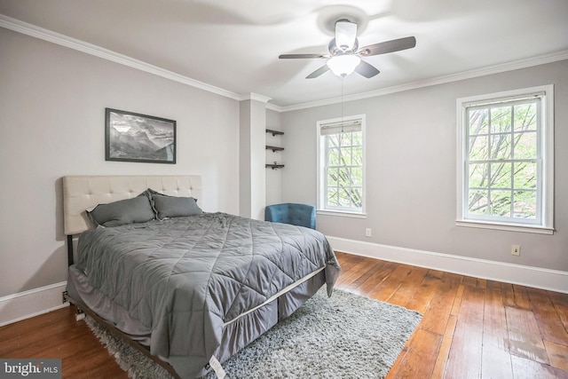 bedroom with baseboards, wood-type flooring, multiple windows, ornamental molding, and a ceiling fan