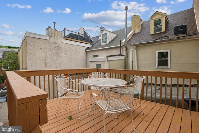 wooden terrace featuring central air condition unit and outdoor dining space