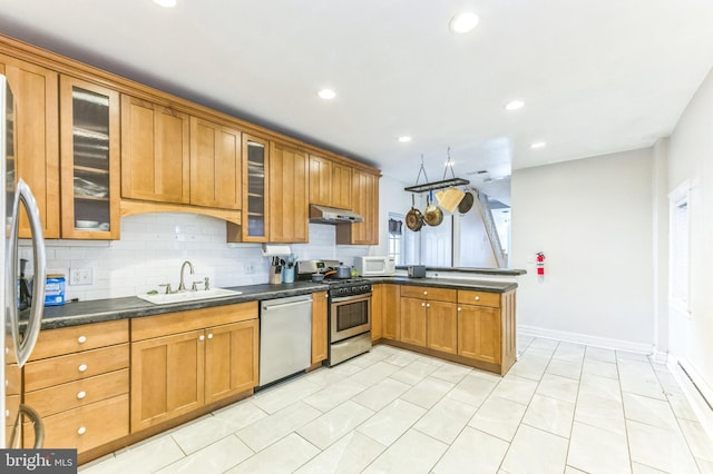 2202 E Cumberland St, Philadelphia, PA 19125 - kitchen with brown cabinetry, appliances with stainless steel finishes, range hood, and a sink