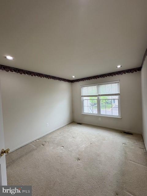 unfurnished room with recessed lighting, light carpet, and baseboards