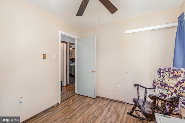 sitting room with a ceiling fan and wood finished floors