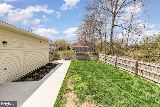 view of yard featuring an outbuilding, a shed, and a fenced backyard
