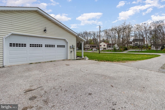 garage featuring driveway and a residential view