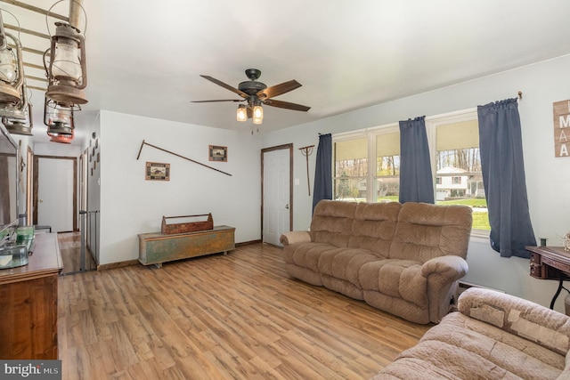 living area with light wood finished floors, baseboards, and a ceiling fan
