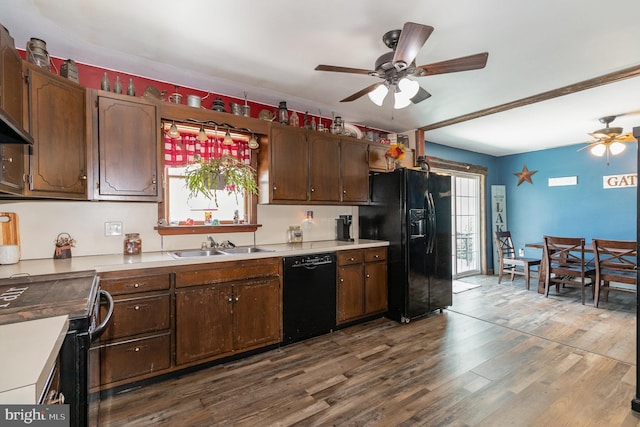 kitchen featuring dark wood-style floors, light countertops, a sink, black appliances, and ceiling fan