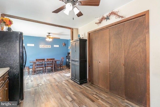 interior space featuring light wood-type flooring, light countertops, a ceiling fan, and freestanding refrigerator