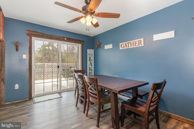 dining area with baseboards, a ceiling fan, and wood finished floors