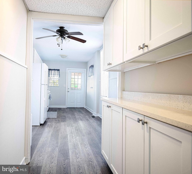 doorway with ceiling fan, baseboards, and dark wood-type flooring