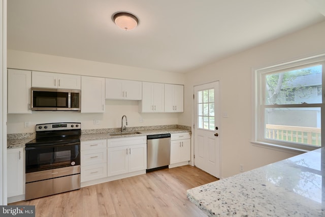 4504 E Joppa Rd, Perry Hall, MD 21128 - kitchen featuring stainless steel appliances, light wood-style flooring, a sink, and white cabinets
