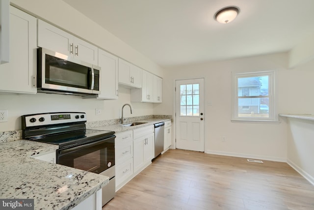 4504 E Joppa Rd, Perry Hall, MD 21128 - kitchen with a sink, light stone counters, light wood-type flooring, white cabinets, and appliances with stainless steel finishes