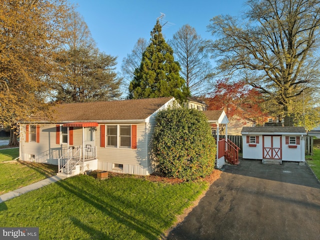 ranch-style house with an outdoor structure, a shed, and a front lawn