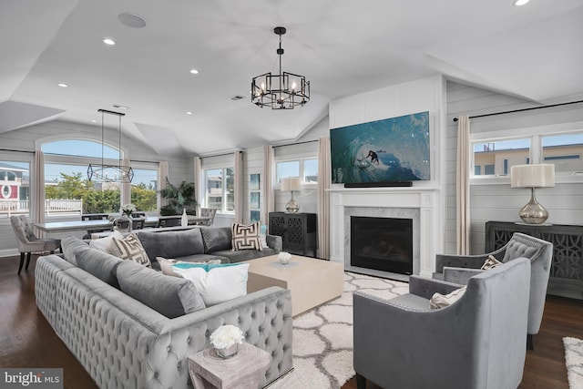 living room with vaulted ceiling, wood finished floors, a chandelier, and visible vents