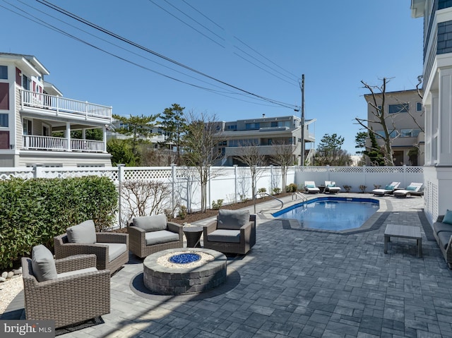 view of swimming pool featuring a patio area, a fenced in pool, an outdoor living space with a fire pit, and a fenced backyard