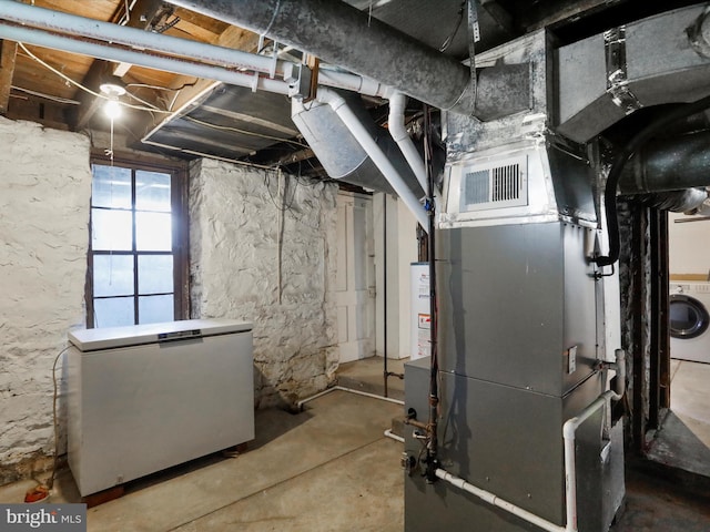 utility room with washer and dryer, visible vents, and water heater