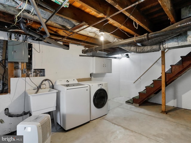 washroom with cabinet space, separate washer and dryer, a sink, and electric panel